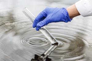 researcher-holds-test-tube-with-water-hand-blue-glove_