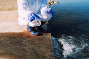 unrecognizable-ecologist-standing-where-sewage-waste-water-meets-river-taking-samples-determine-level-contamination-pollution_